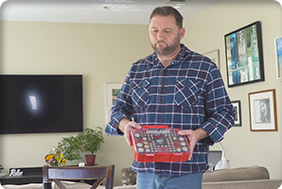 Man holding  Battery Daddy® Slim in his living room