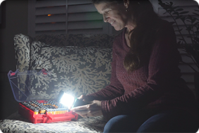 Woman using a flashlight to find the right battery